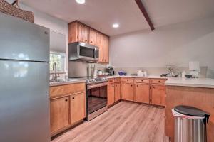 a kitchen with wooden cabinets and a stainless steel refrigerator at Cozy Toledo Bend A-Frame with Waterfront Views! in Burkeville