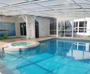 a large pool with blue water in a building at Duna Parque Beach Club - Duna Parque Group in Vila Nova de Milfontes