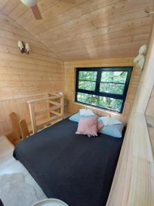 ein Schlafzimmer mit einem großen Bett in einer Holzhütte in der Unterkunft Węgiełek Treehouse in Kazimierz Dolny