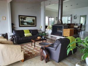 a living room with a couch and a fireplace at Lind End Guest Farm in Haenertsburg