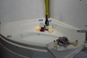 bañera llena de agua con velas y botellas en West Horizon holiday cottage, en Lochinver
