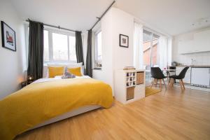 a bedroom with a yellow bed and a table and chairs at Studio Shiny - Zentral mit Balkon - Messe - Küche in Neuss