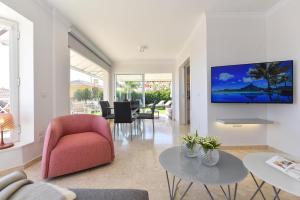 Chalet Santa Ana 19 by VillaGranCanaria في بلايا ديل إنغلز: غرفة معيشة مع كرسي احمر وتلفزيون