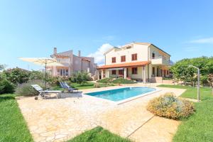 a villa with a swimming pool and a house at Villa Marija in Medulin