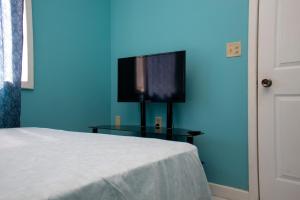 a blue room with a bed and a television on a table at Bliss on the Bay in West End