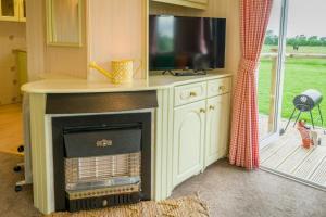 a living room with a fireplace with a tv on top at Toad Hall, Self Catering, Sleeps Four in Southam