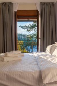 Una cama con toallas en la parte superior frente a una ventana en Bella Villa, en Vrnjačka Banja
