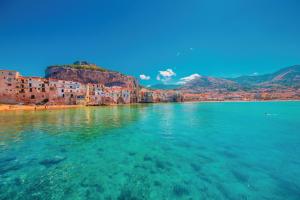 a view of a body of water with buildings and houses at Suite Bordonaro Apartments in Cefal&ugrave;