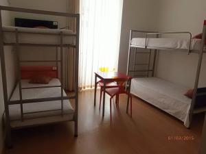 a room with two bunk beds and a table at HI Tavira – Pousada de Juventude in Tavira