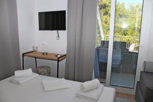 a room with two beds and a table and a television at Oneiro Zois in Prinos