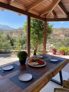 een houten tafel met een bord eten erop bij Lithines Villa go green in Dhafnés
