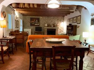 ein Wohnzimmer mit einem Tisch, einem Sofa und einem Kamin in der Unterkunft Euganean Hills Natural Park: Casale Il Boschetto in Torreglia