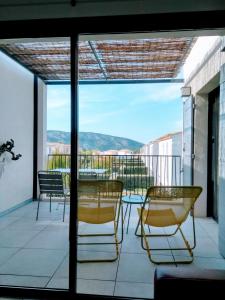 a balcony with a table and chairs and a view at Les Cyclistes in Malaucène