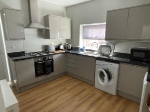 a kitchen with a washing machine and a sink at Dorchester central flat in Dorchester