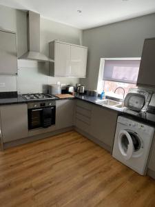 a kitchen with a sink and a washing machine at Dorchester central flat in Dorchester