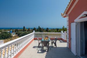 uma varanda de uma casa com uma mesa e cadeiras em Five Stars Villa em Skála Kefalonias