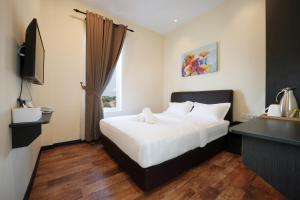a hotel room with a bed and a window at Hotel Le-Shore in Kuala Selangor