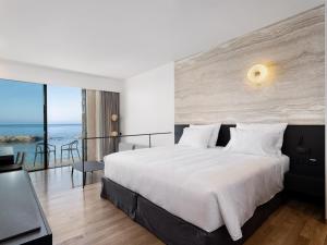 a bedroom with a bed and a view of the ocean at The Tanneries Hotel & Spa in Chania