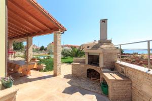 a patio with an outdoor pizza oven in a backyard at Villa Marija in Medulin