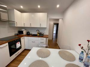 a kitchen with white cabinets and a white table at Apartament Weronika in Gryfów Śląski