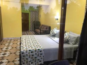 una camera con letto e divano di John's Highland Comfort (Guest House) a Majorda