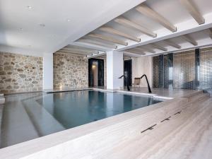 a swimming pool in a room with a stone wall at The Tanneries Hotel & Spa - a Member of Design Hotels in Chania