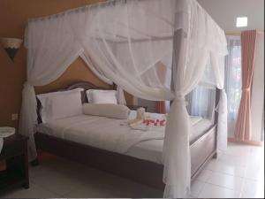 una camera con letto a baldacchino e tende bianche di Villa de Owis a Labuan Bajo