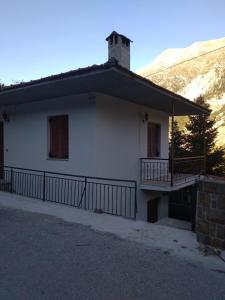 a white house with a balcony and a mountain at Aetofolia Melissourgoi in Melissourgoi