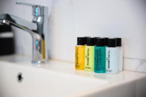 three bottles ofodorizers sitting on a bathroom sink at The Roomy Hotel Nişantaşı in Istanbul