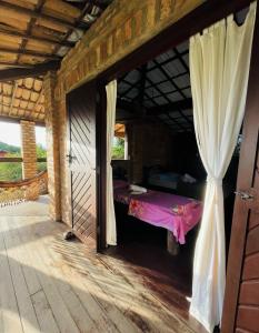 a room with a bed and a window with a curtain at Hostel do Ceu in Pipa