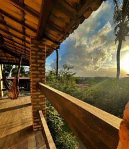 a porch of a wooden house with a hammock at Hostel do Ceu in Pipa