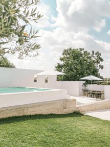 a swimming pool with a table and umbrellas at Casa no Montinho in Ourique