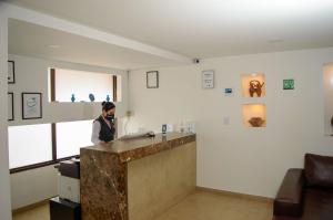 a woman standing at a counter in a room at Hotel Castellana 95 in Bogotá