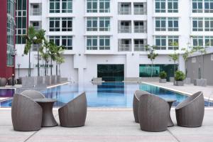 a hotel swimming pool with chairs and a building at UTM Hotel & Residence in Kuala Lumpur