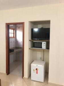 a small kitchen with a microwave and a tv at Pousada Esperança in Boa Esperança