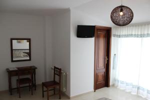 Cette chambre dispose d'une porte, d'une chaise et d'une table. dans l'établissement Hotel Estrella del Mar, à A Lanzada