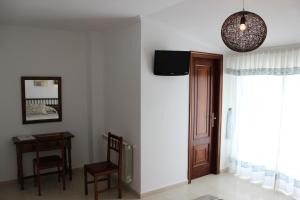 Habitación con puerta, silla y mesa en Hotel Estrella del Mar en A Lanzada