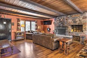 a living room with a couch and a stone fireplace at The Lodge at Valhalla at Powderhorn Ski Resort! in Bessemer