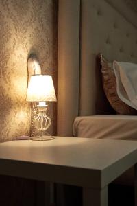 a lamp sitting on a table next to a bed at Cocos Hotel in Rostov on Don