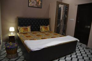 齋浦爾的住宿－Laxmi Residence，一间卧室配有一张带黑色床头板的床