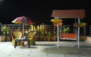 2 ombrelloni e un tavolo con sedie su un patio di Laxmi Residence a Jaipur