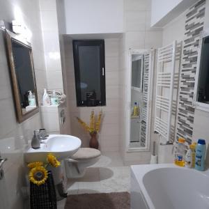 ein weißes Badezimmer mit Waschbecken, Toilette und Badewanne in der Unterkunft Apartment River in Bacău + 18 Fotos