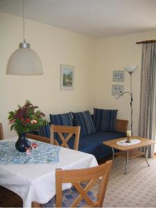 a living room with a blue couch and a table at Landhaus Fellnerbauer in Bad Reichenhall