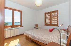 a bedroom with a bed and two windows at Villa Marija in Medulin