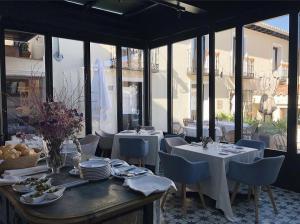 a restaurant with white tables and chairs and windows at Hotel Boutique Casa del Comendador in Navalcarnero