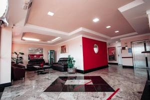 a lobby with a red wall and couches at Plaza Dutra Hotel in Caçapava