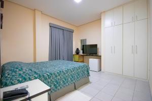 a hotel room with a bed and a television at Plaza Dutra Hotel in Caçapava