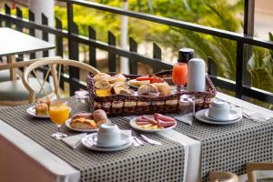 uma mesa com uma cesta de comida para o pequeno-almoço numa varanda em Plaza Dutra Hotel em Caçapava