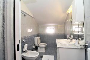 a bathroom with two sinks and a toilet in it at Charm Penthouse Ocean View in Calheta +14 photos