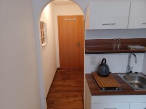 a kitchen with a sink and a hallway with a door at Stubnerblick in Bad Gastein